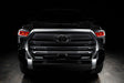  Straight front view of a black Toyota Tundra with red demon eye projectors.