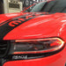 Close-up of a Dodge Charger headlight installed with red DRLs.