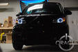 Smart Car with white LED headlight halo rings installed.