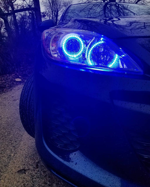 Close-up of Mazda 3 headlight with blue LED halo rings installed.