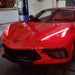 Front end of a red C8 Corvette with red headlight DRLs.