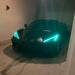 Front end of a black C8 Corvette with cyan headlight DRLs.