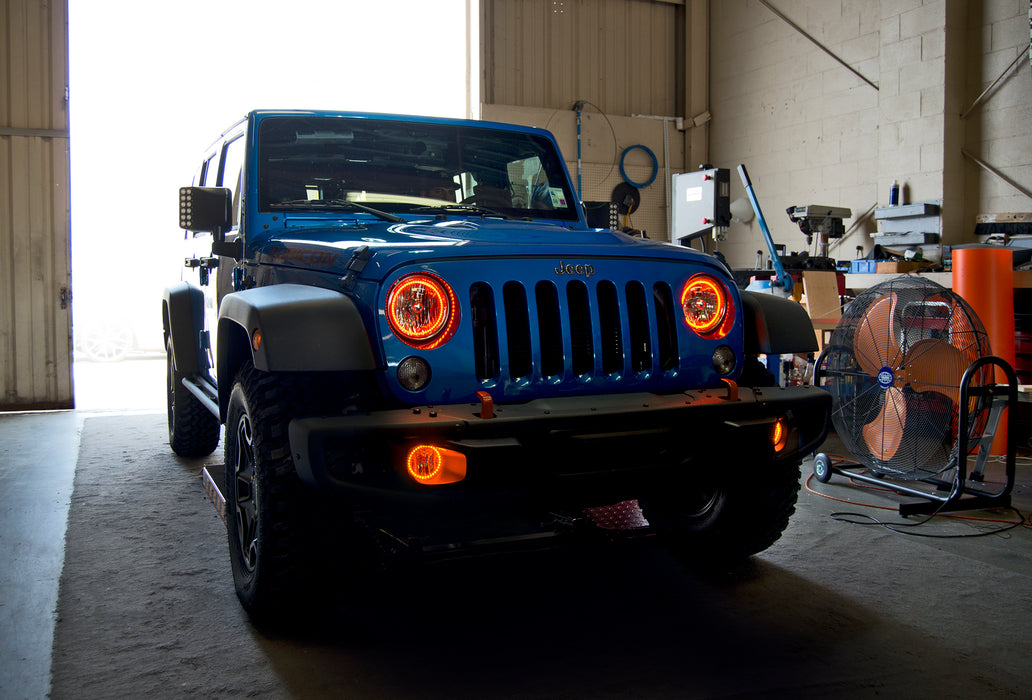 Three quarters view of a Jeep Wrangler with amber LED headlight and fog light halos installed.