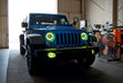 Three quarters view of a Jeep Wrangler JK with green LED headlight and fog light halo rings installed.