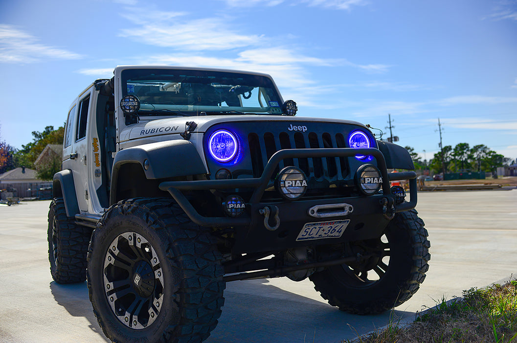 Three quarters view of a Jeep Wrangler JK with blue LED headlight halos installed.