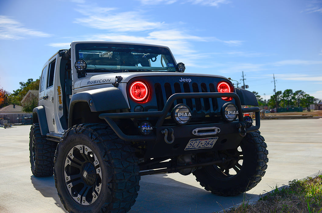Three quarters view of a Jeep Wrangler JK with red LED headlight halos installed.