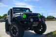 Three quarters view of a Jeep Wrangler JK with green LED headlight halos installed.