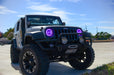 Three quarters view of a Jeep Wrangler JK with purple LED headlight halos installed.