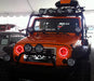 Front end of a Jeep Wrangler JK with red LED headlight halos installed.