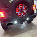 Rear end of a Jeep Wrangler JL with bright reverse lights on.