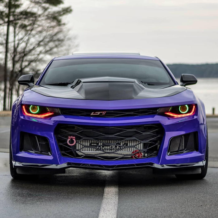 Purple Camaro with green projector halos and red DRLs.