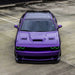 Purple Dodge Challenger with green LED headlight halo rings.