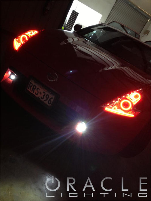 Front end of a Nissan 370Z with red LED headlight halo rings installed.