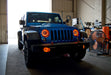 Three quarters view of a Jeep Wrangler JK with amber LED headlight and fog light halos installed.