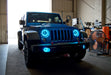 Three quarters view of a Jeep Wrangler JK with cyan LED headlight and fog light halos installed.