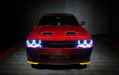 Front end of a red Dodge Challenger with white halo headlights.