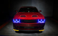 Front view of a red Dodge Challenger with blue LED headlight halo rings installed.