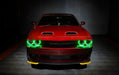 Front view of a red Dodge Challenger with green LED headlight halo rings installed.