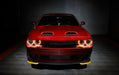 Front end of a red Dodge Challenger with amber halo headlights.