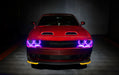 Front view of a red Dodge Challenger with purple LED headlight halo rings installed.