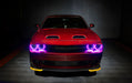 Front view of a red Dodge Challenger with pink LED headlight halo rings installed.