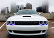 Front end of a white Dodge Challenger with white LED headlight halo rings installed.