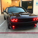 Black Dodge Challenger with red LED headlight and fog light halo rings.
