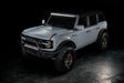 Three quarters view of a grey Ford Bronco with multiple ORACLE Lighting products installed, including the Integrated Windshield Roof LED Light Bar System.