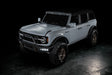 Three quarters view of grey Ford Bronco with Triple LED Fog Lights turned on.