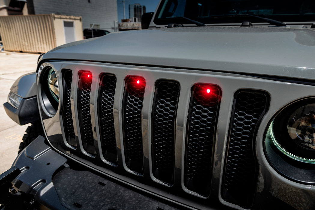 Close-up on the front end of a Jeep Wrangler with red LED Grill Light Kit.