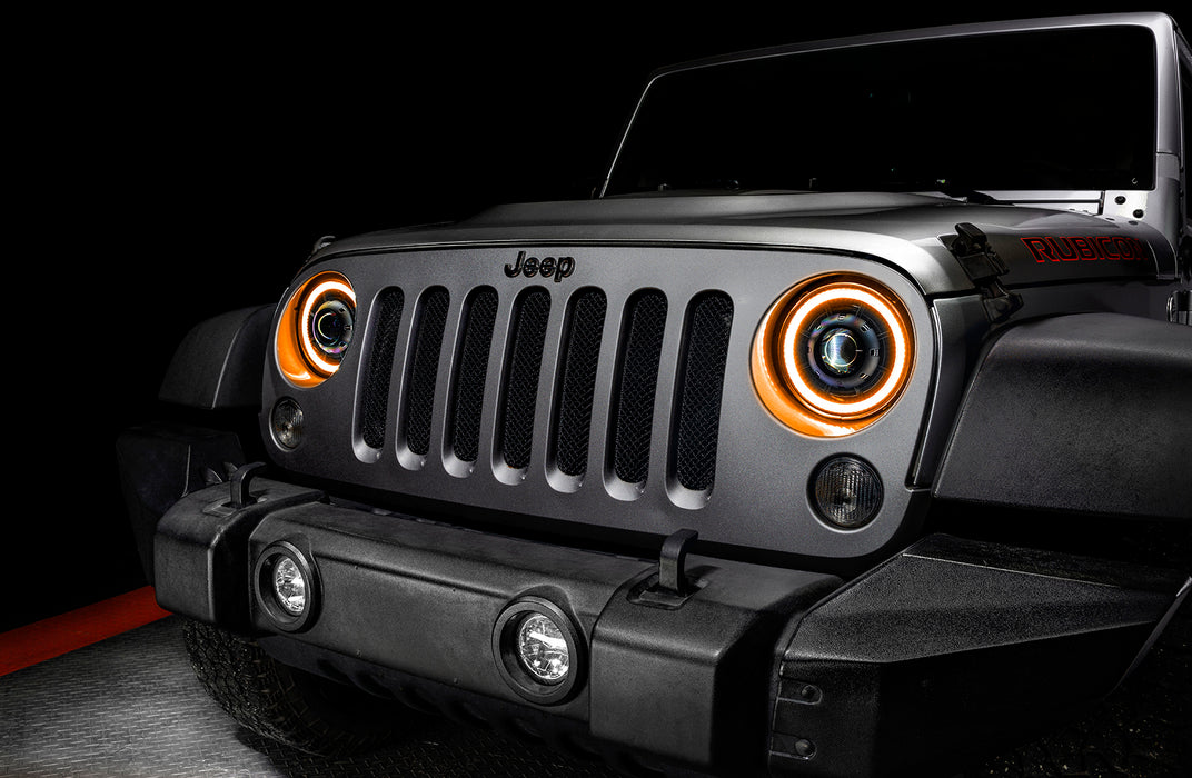 Close-up on the front end of a Jeep Wrangler JK with 7" Oculus Switchback Headlights installed and set to amber LED.