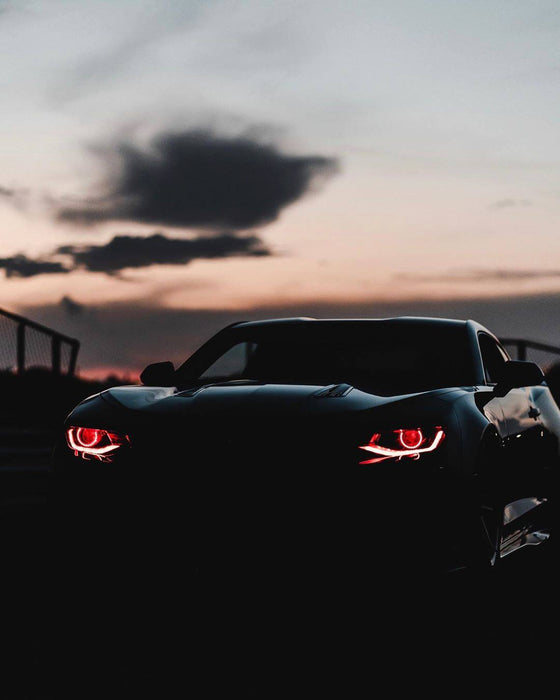 Black Camaro with red projector halos and DRLs.