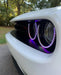 Close-up of purple LED headlight halo rings installed on a Dodge Challenger.