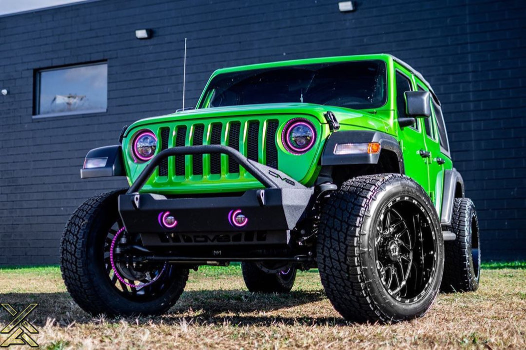 Three quarters view of a green Jeep with pink headlight and fog light halos.