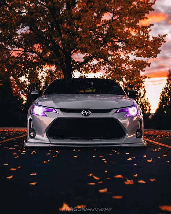 Front end of a Scion tC with purple LED headlight halo rings installed.