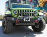 Front end of a green Jeep Wrangler with Oculus Headlights installed.