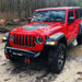 Red Jeep Wrangler driving through the mud, equipped with Oculus Headlights.