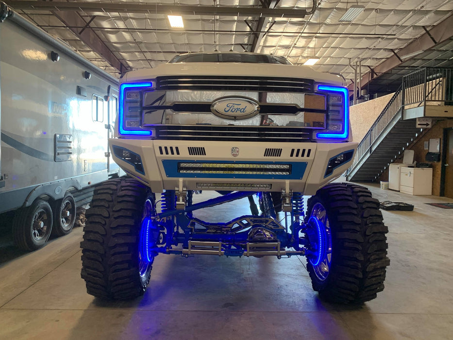 Lifted Ford Super Duty with blue wheel rings and headlight DRLs.