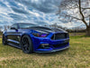 Blue mustang in the grass outside with rainbow DRL and halos