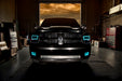 Front end of a RAM truck with Switchback Quad Pre-Assembled Halo Headlights installed and cyan halos on.