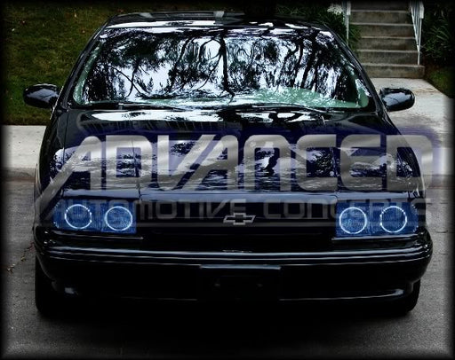 Front end of a Chevrolet Impala with blue LED headlight halo rings installed.