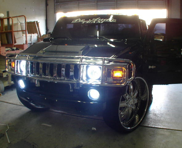 Front end of a Hummer H2 with white LED headlight and fog light halos.
