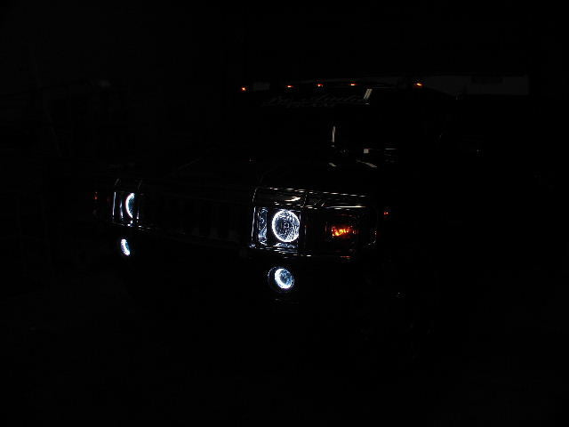 Front end of a Hummer H2 with white LED headlight and fog light halos.