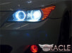 Close-up of white LED headlight halo rings installed on a BMW 5 Series.