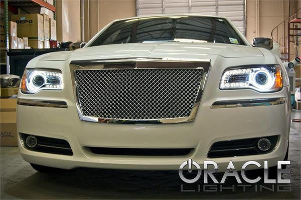 Front end of a Chrysler with white LED headlight halo rings installed.