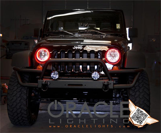 Front end of a Jeep Wrangler JK with red LED headlight halo rings installed.