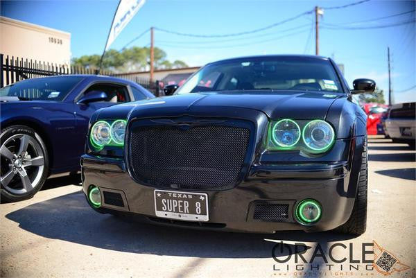 Front end of a Chrysler 300 with green LED headlight and fog light halo rings installed.