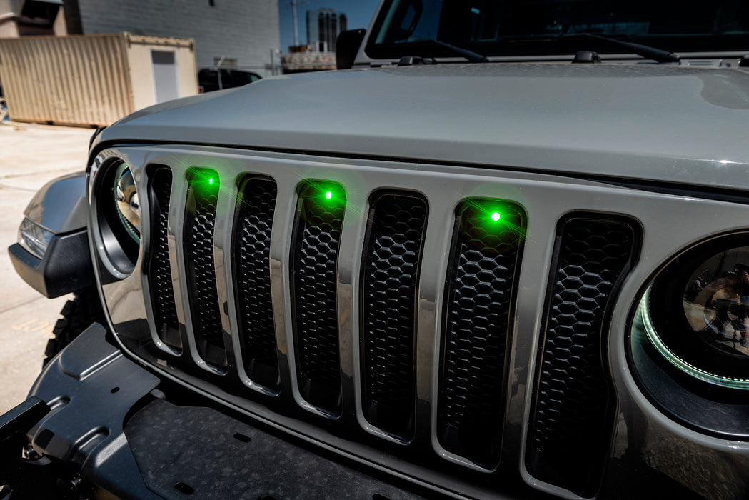 Close-up on the front end of a Jeep Wrangler with a green LED Grill Light Kit.