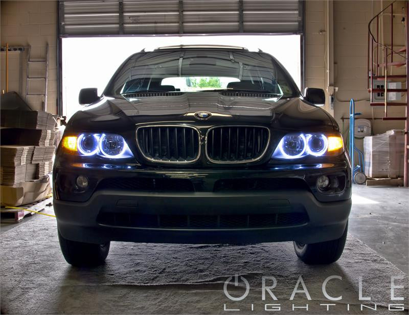 Front end of a BMW X5 with white LED headlight halo rings.