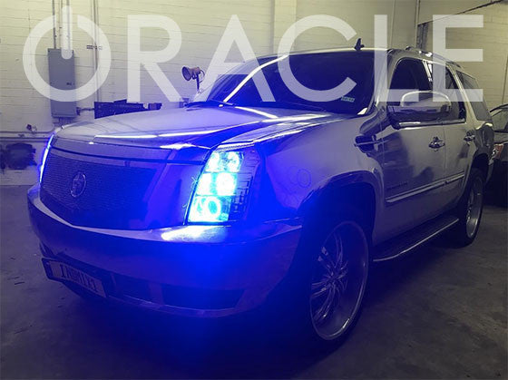 Three quarters view of a Cadillac Escalade with blue LED headlight halo rings.